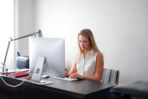 A journalist reading a pitch on her computer.