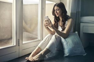 A woman looking at local news on her phone.