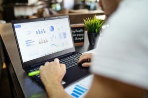 A person looking at charts on a computer.