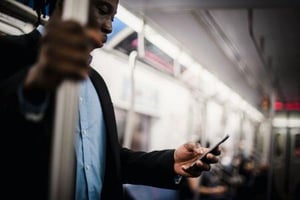 A man reading a newsletter on his phone.